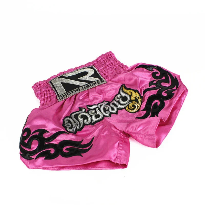 Pink Muay Thai boxing shorts with black tribal designs and embroidered logo on waistband