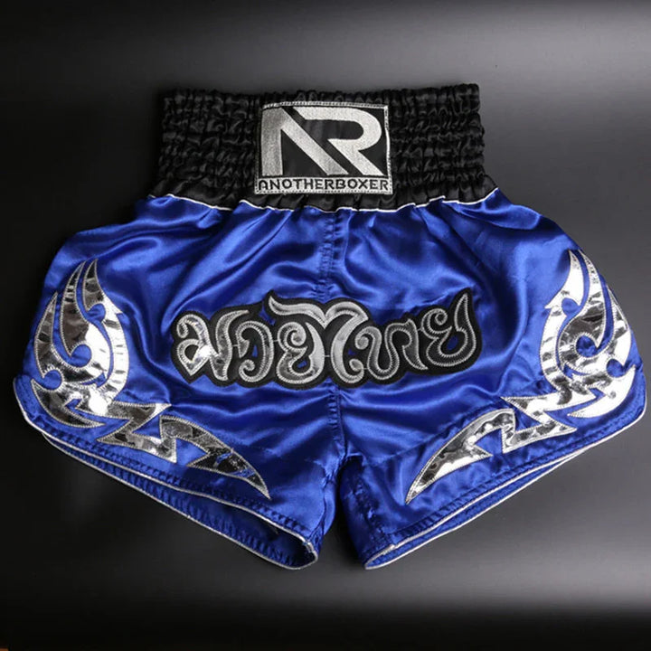 Blue Muay Thai shorts with silver tribal patterns and AnotherBoxer logo on waistband