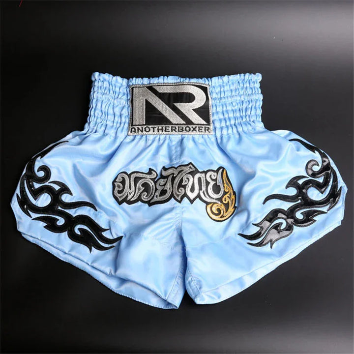 Light blue Muay Thai boxing shorts with black tribal designs and AnotherBoxer logo