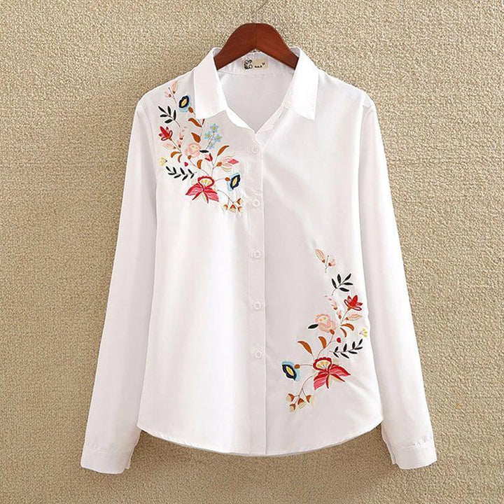 White long-sleeve button-up shirt with colorful floral embroidery on chest and hem