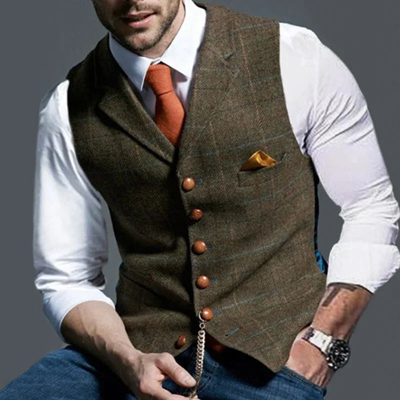 Man wearing brown tweed waistcoat with wooden buttons, white shirt, orange tie, and pocket square