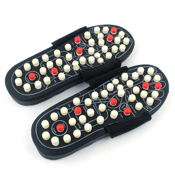 Pair of black reflexology acupressure massage sandals with white and red massage nodes for foot therapy