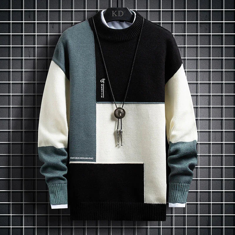 Color-block knit sweater in black, white, and teal with a pendant necklace on grid background