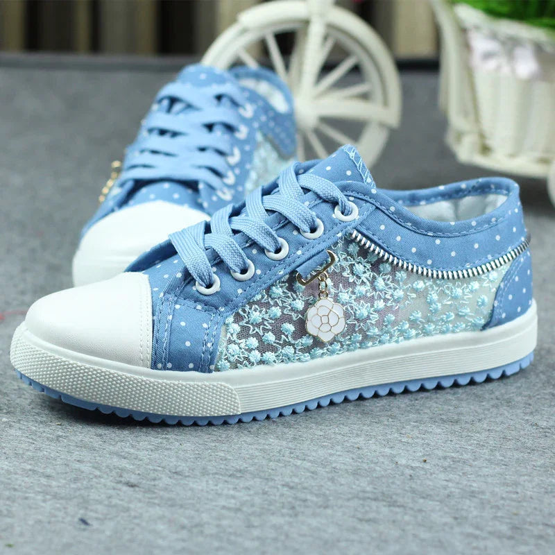 Light blue lace sneakers with polka dot fabric, white toe caps, and floral charm detail