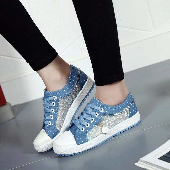 Stylish blue denim sneakers with lace and polka dot design, white rubber soles, worn with black leggings