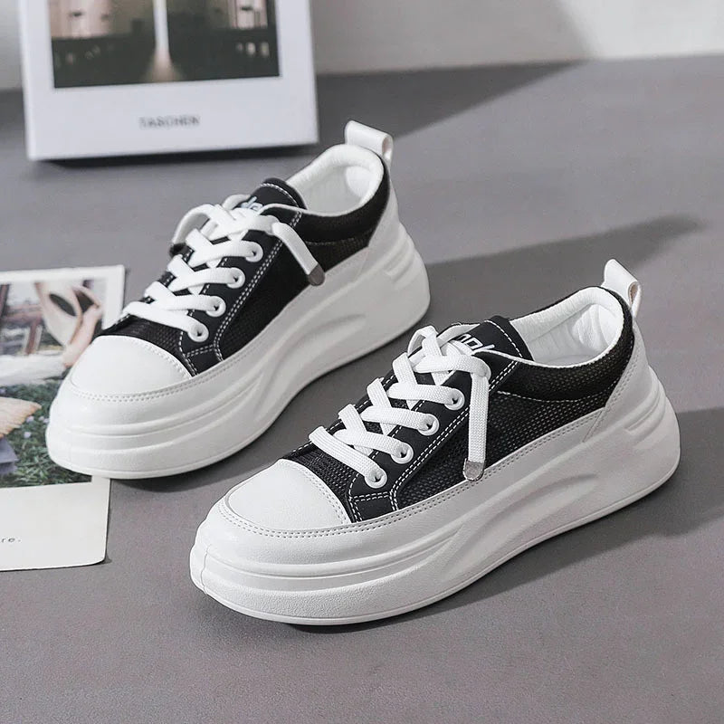 Black and white platform sneakers with thick soles on gray surface