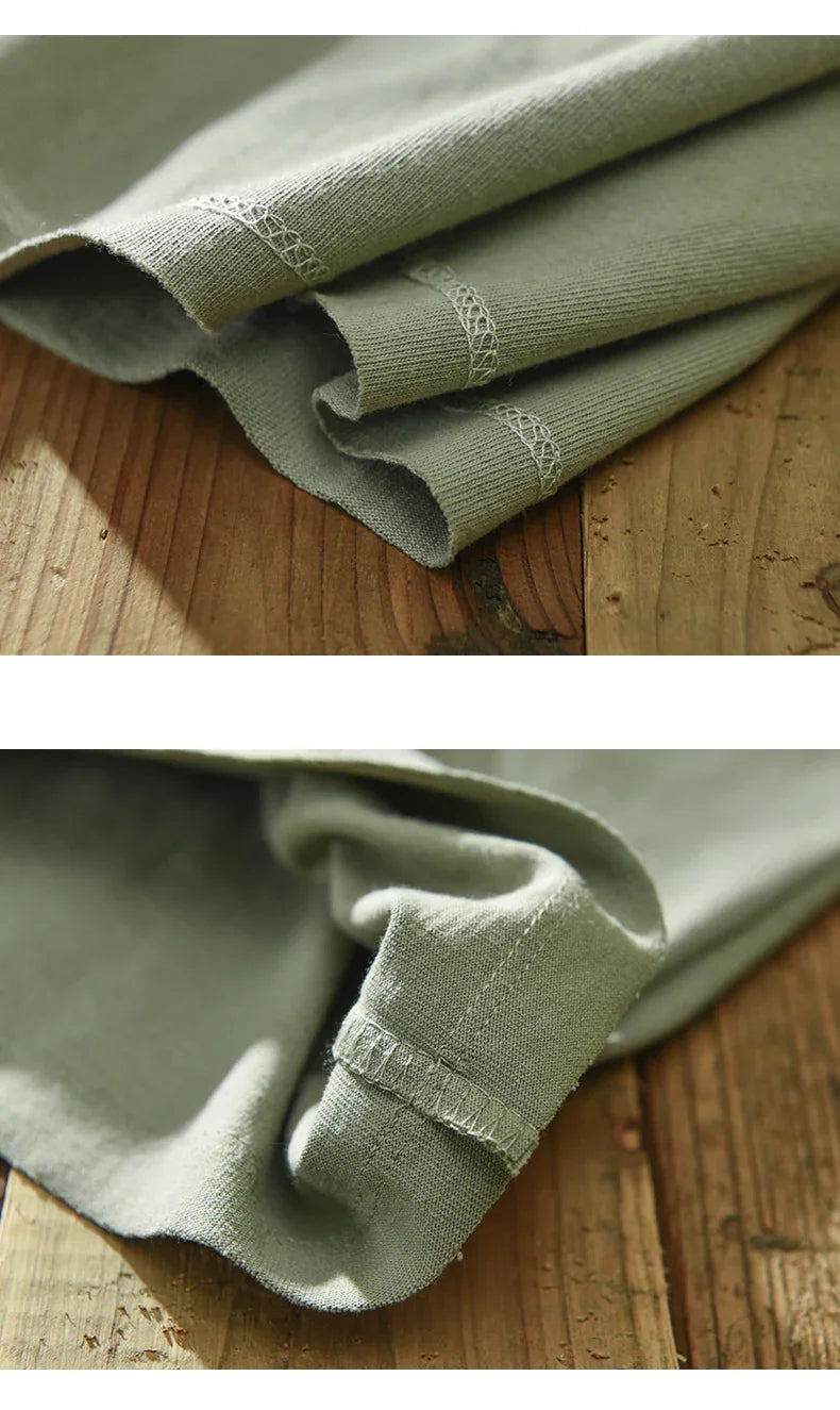 Close-up of olive green fabric with detailed stitching on wooden surface