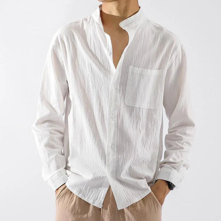 Men's casual white button-up shirt with chest pocket, textured fabric, paired with brown pants