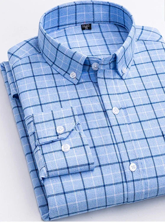 Folded light blue checkered button-down shirt with long sleeves on white background