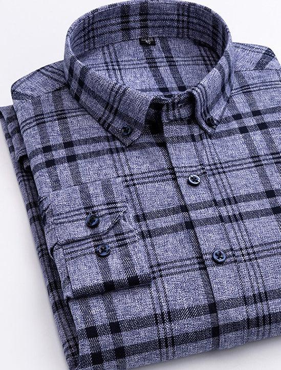 Folded blue and black plaid flannel shirt with buttoned collar and cuffs on white background