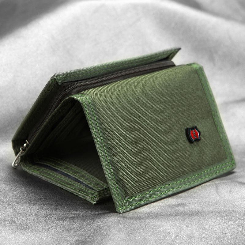 Green fabric wallet with zipper compartment and small red logo on gray surface