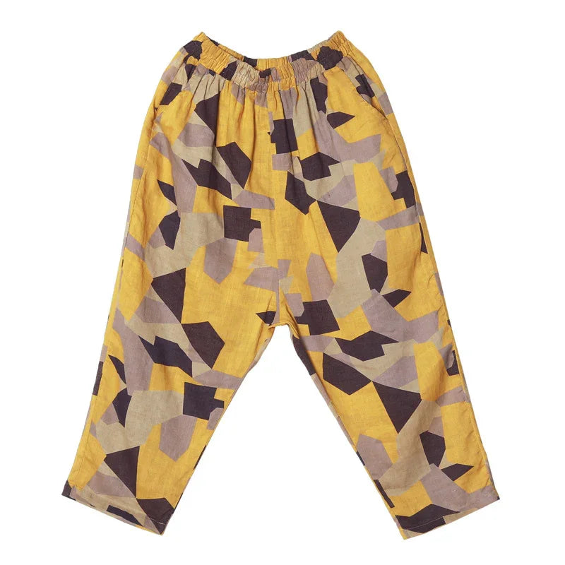 Yellow loose-fit pants with abstract geometric black and gray pattern and elastic waistband