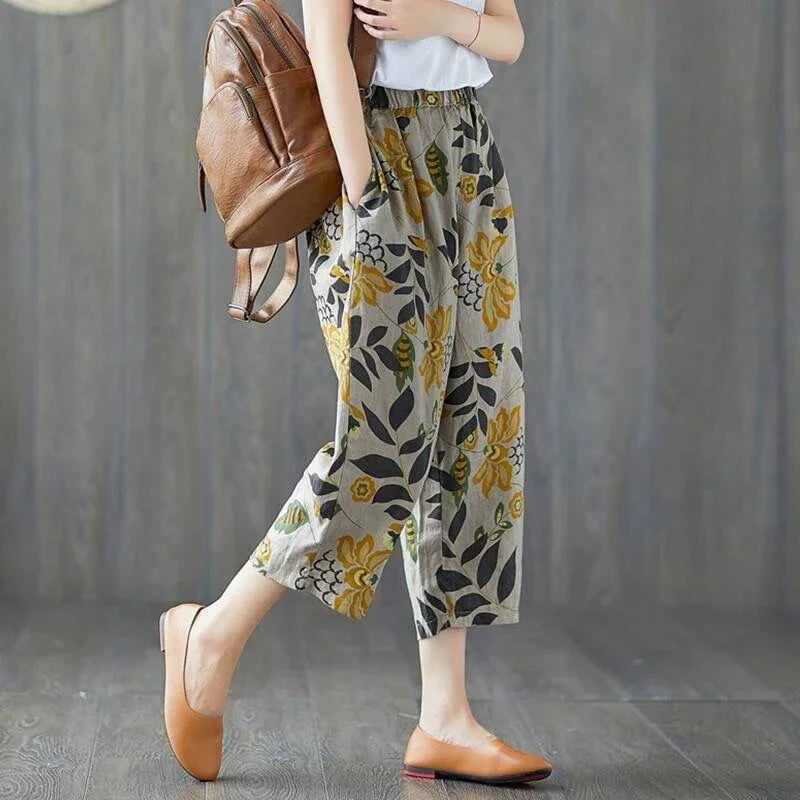 Woman wearing floral wide-leg cropped pants with yellow flowers and carrying brown leather backpack