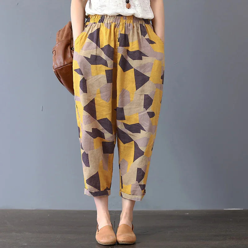 Person wearing loose, colorful geometric print pants with rolled cuffs and tan slip-on shoes
