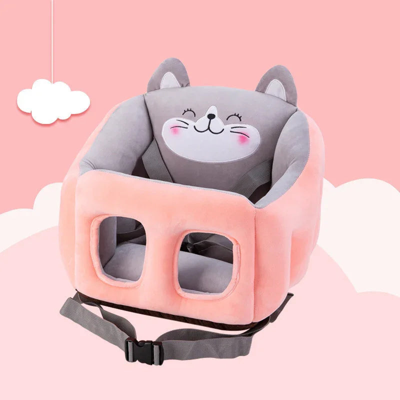 Pink and gray plush baby seat with cat face design and safety straps on pastel pink background