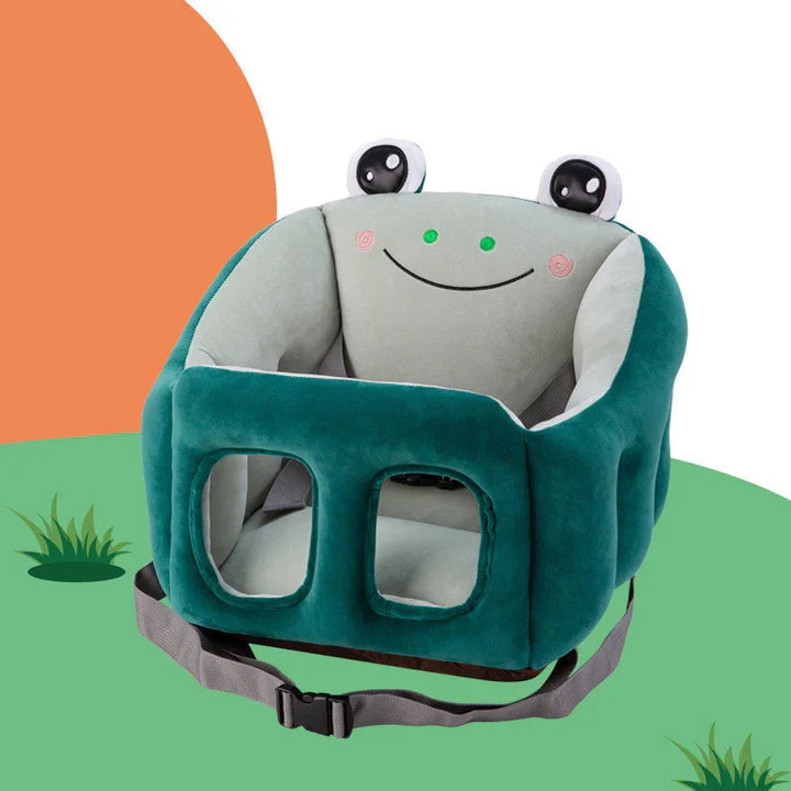 Green frog-themed baby booster seat with safety strap and smiling face design