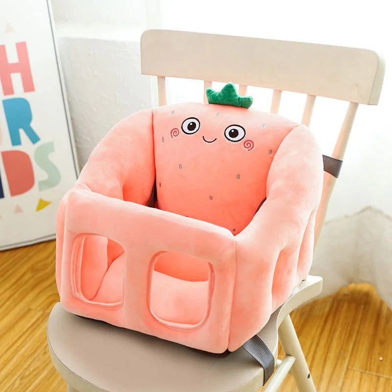 Soft pink plush strawberry baby booster seat with smiley face on wooden chair in bright room