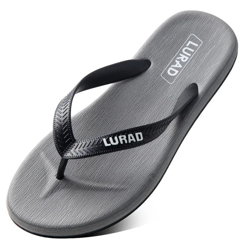 Gray LURAD flip flop sandal with textured black straps on white background