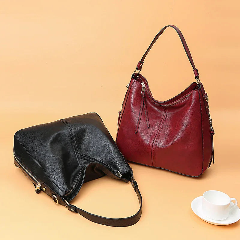 Two leather handbags, one black and one red, displayed on a beige background with a white cup and saucer