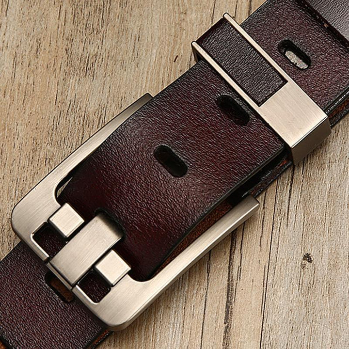 Close-up of dark brown leather belt with silver metal buckle on wooden surface