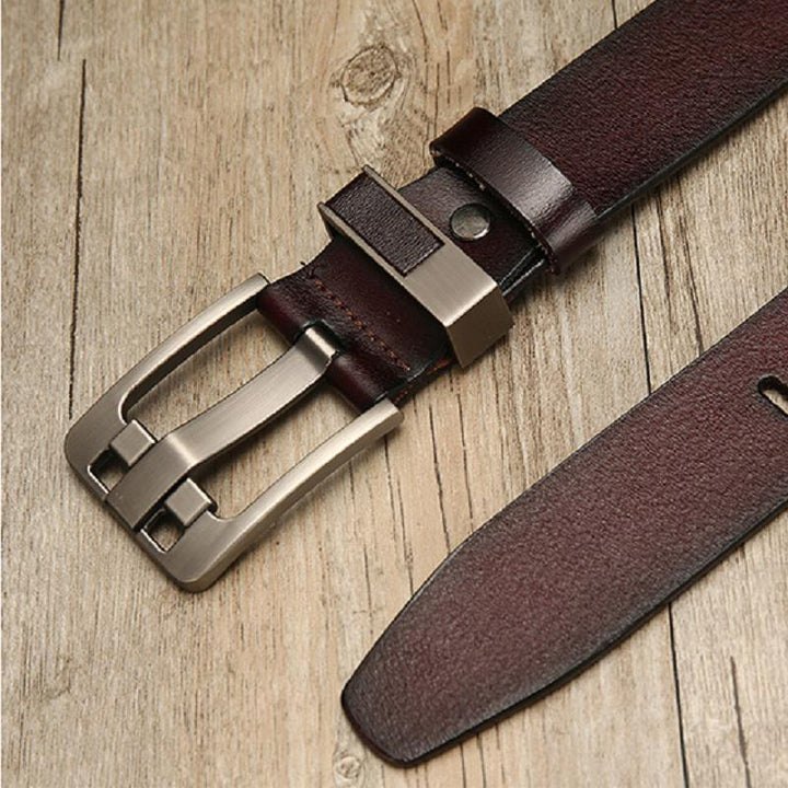 dark brown leather belt with brushed metal buckle on wooden surface