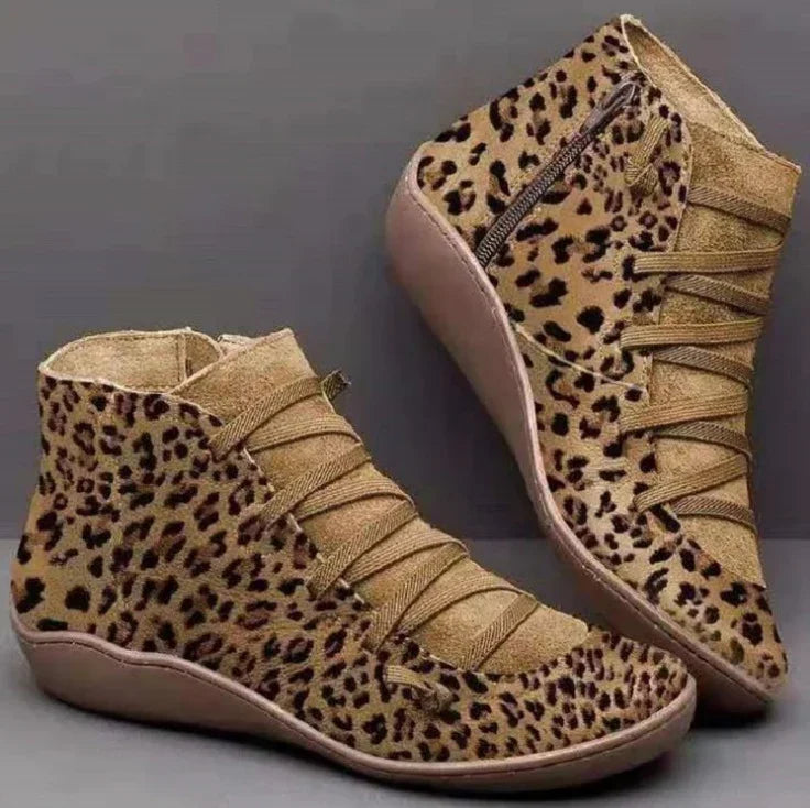 Pair of leopard print high-top wedge sneakers with beige laces and side zipper on gray background