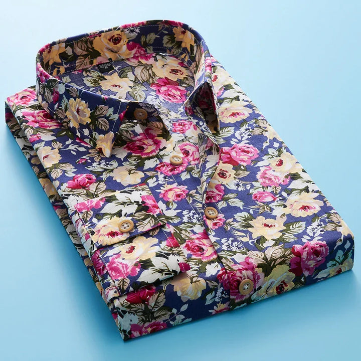 Folded floral print shirt with pink and cream flowers on blue background, wooden buttons, on light blue surface
