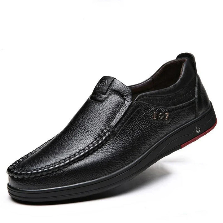Black men's leather casual slip-on shoe with textured finish and stitched detail