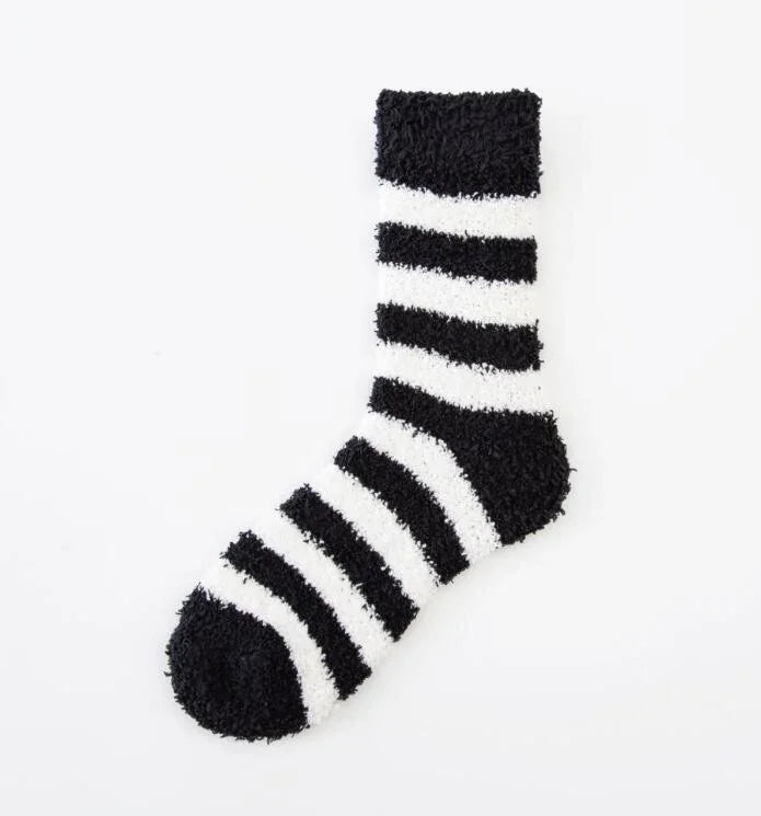 Black and white fuzzy striped cozy sock with alternating thick stripes on a white background