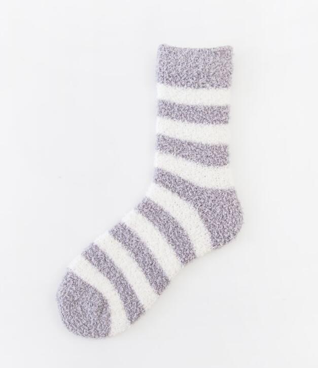 Soft fuzzy sock with gray and white horizontal stripes on white background