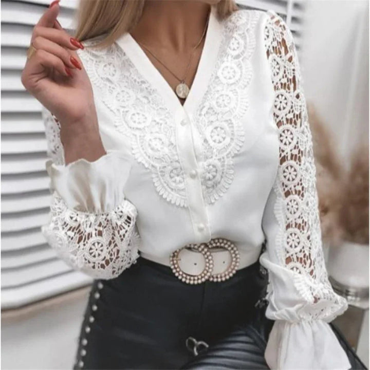 White lace blouse with floral embroidery and pearl button details paired with black leather pants and pearl buckle belt