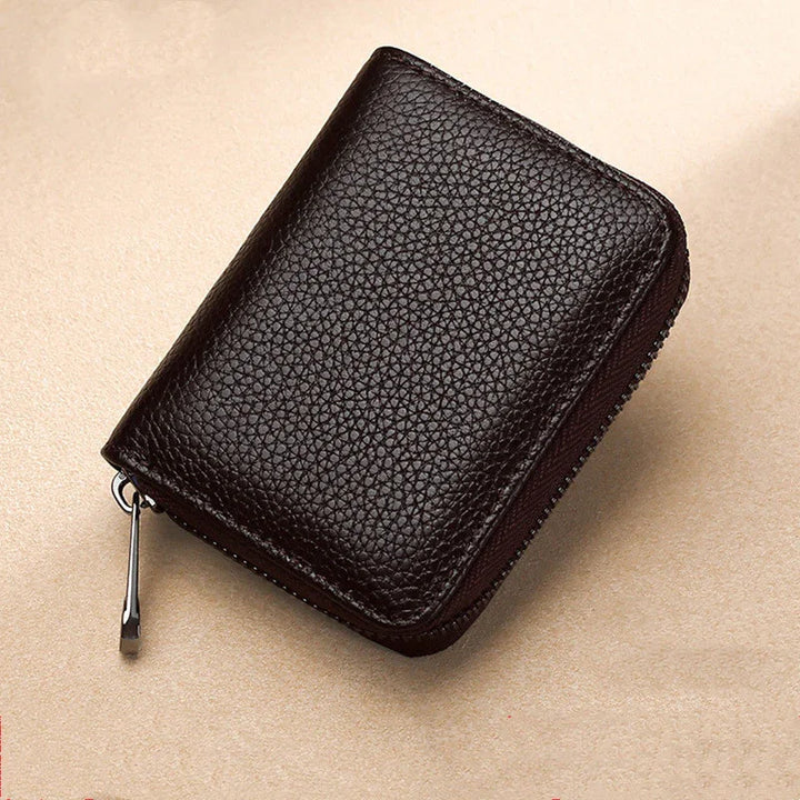 Black textured leather zippered wallet on beige surface, compact travel accessory