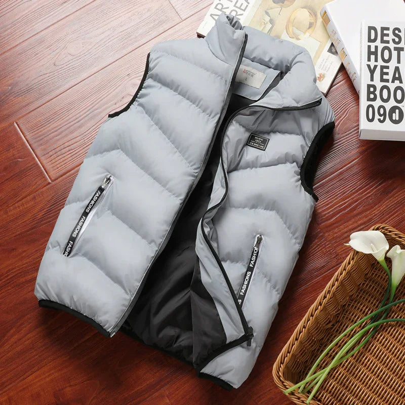 Light grey padded sleeveless vest with black zipper and pocket details on wooden surface