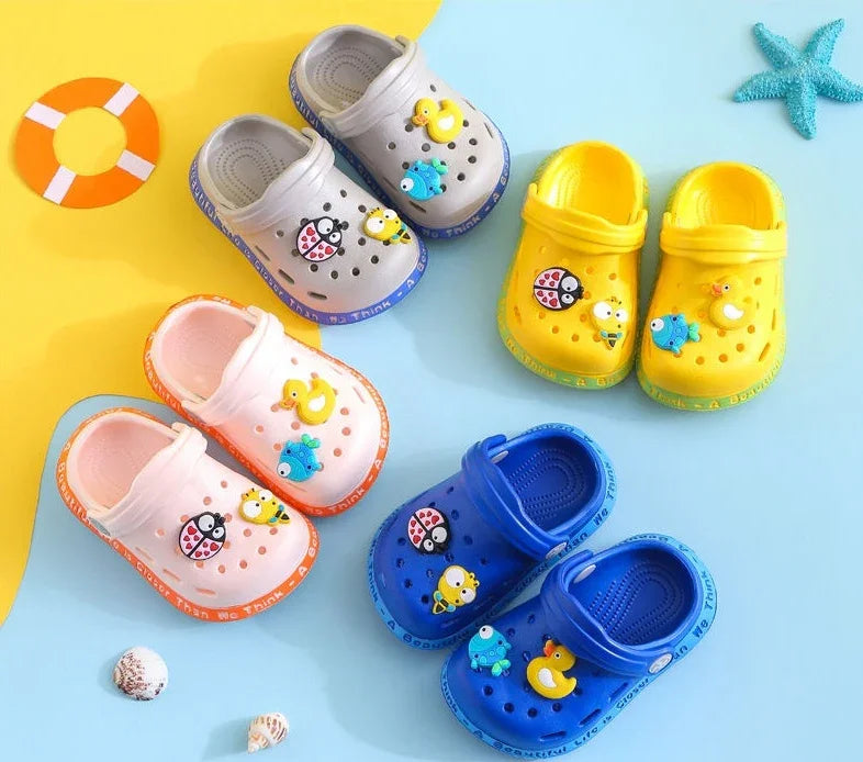 Colorful kids' clogs in gray, yellow, pink, and blue with cute animal charms on a blue and yellow background