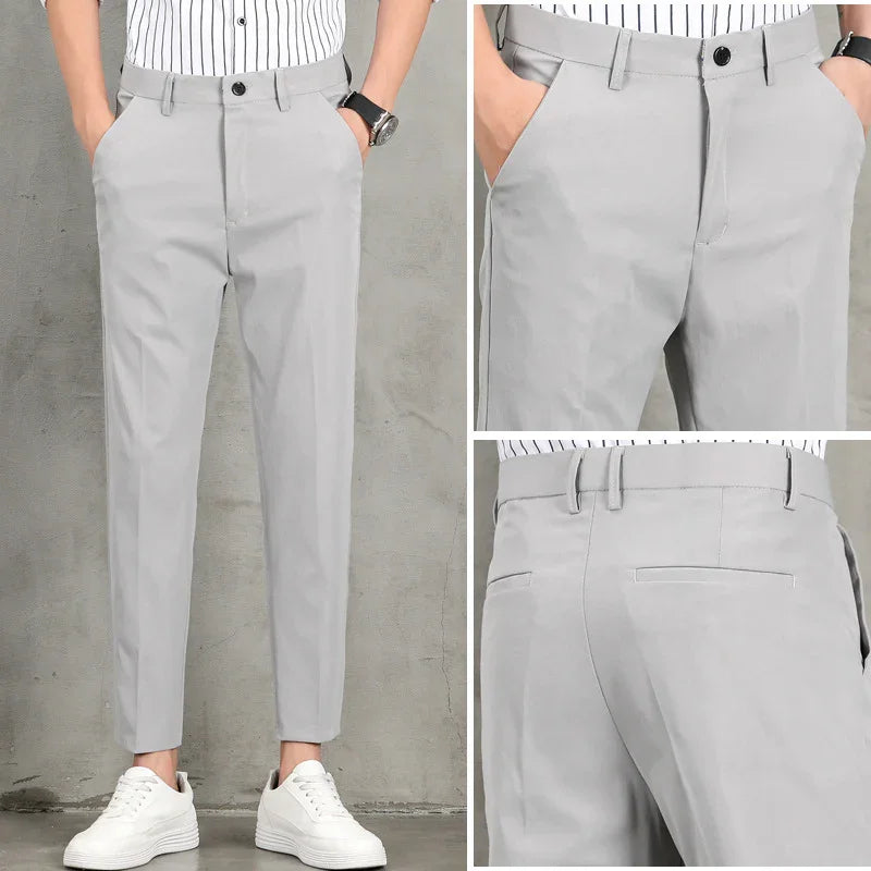 Men's slim fit light gray dress pants with black button, paired with white sneakers and striped shirt