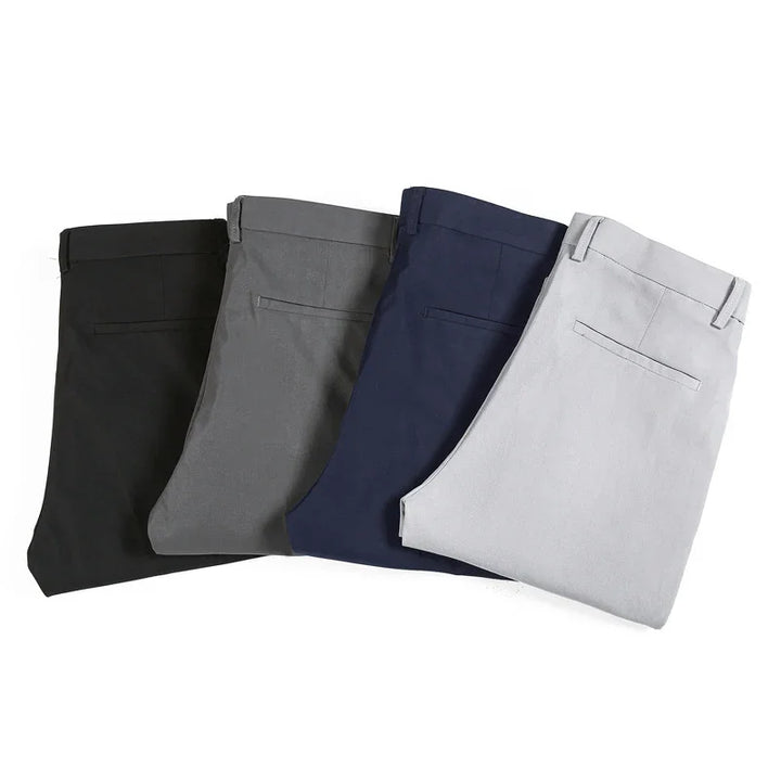 Folded men's dress pants in black, gray, navy blue, and light gray arranged side by side