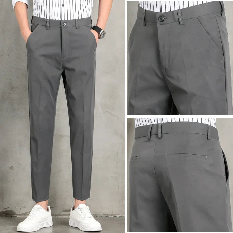 Men's slim fit gray dress pants with pockets, belt loops, and button closure worn with white sneakers