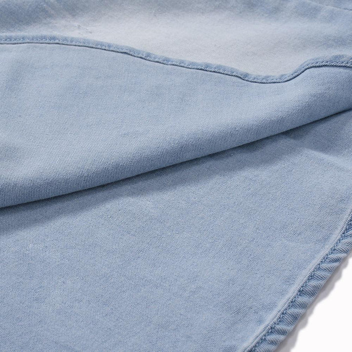 Close-up of light blue denim fabric with visible seams and texture