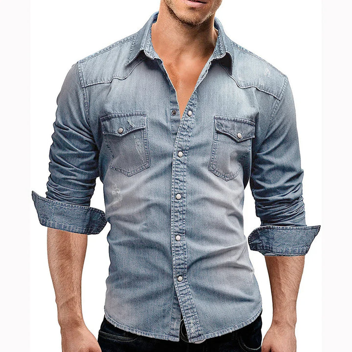 Man wearing fitted faded blue denim shirt with rolled-up sleeves and snap buttons