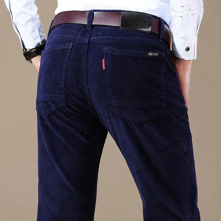 Close-up of man wearing navy blue corduroy jeans with brown leather belt and white shirt