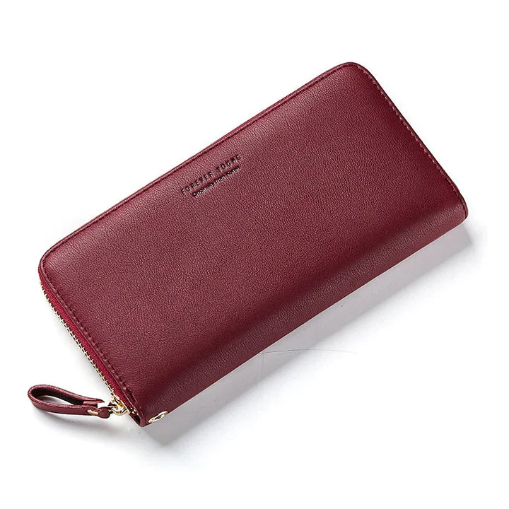 Elegant maroon leather zip-around wallet with wrist strap and minimalist design