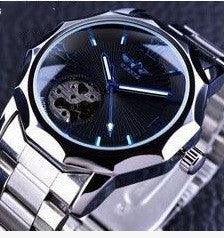 Close-up of stylish wristwatch with black dial, luminous blue hands, and stainless steel band