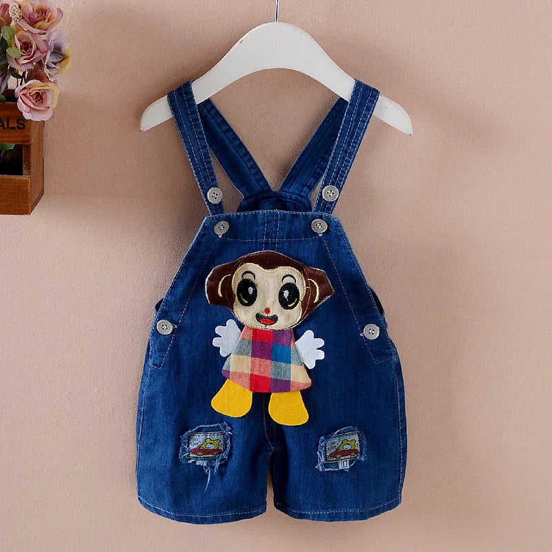 Blue denim baby overalls with cartoon monkey patch and colorful plaid outfit hanging on white hanger