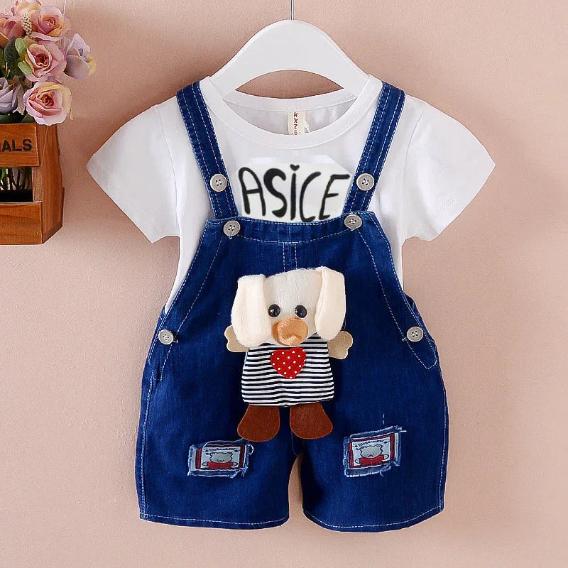 Baby outfit with white t-shirt and blue denim overalls featuring a plush dog and heart design