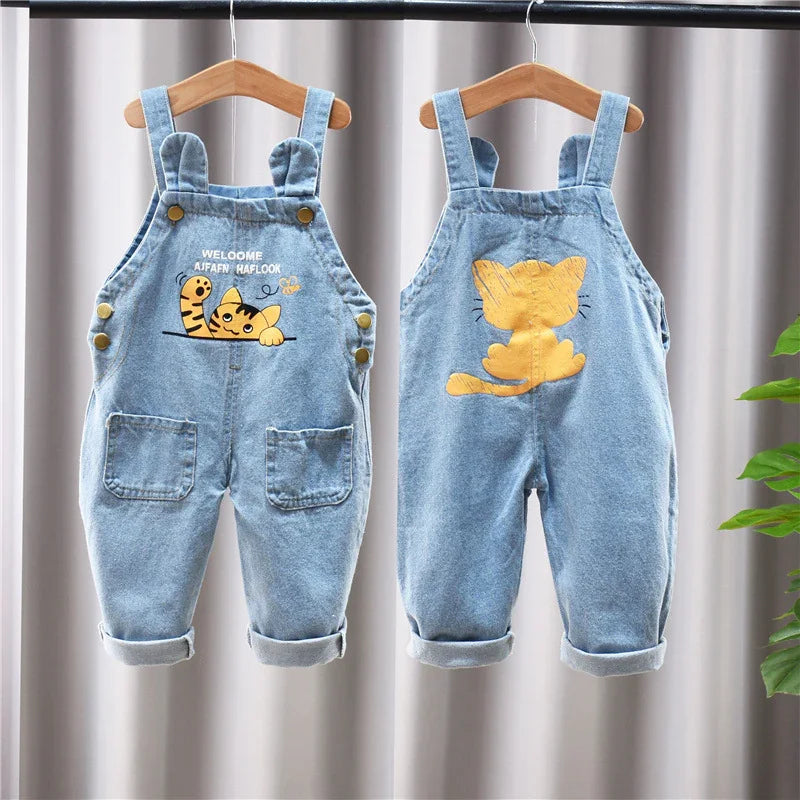 Front and back of light blue denim toddler overalls with cartoon cat and rolled cuffs