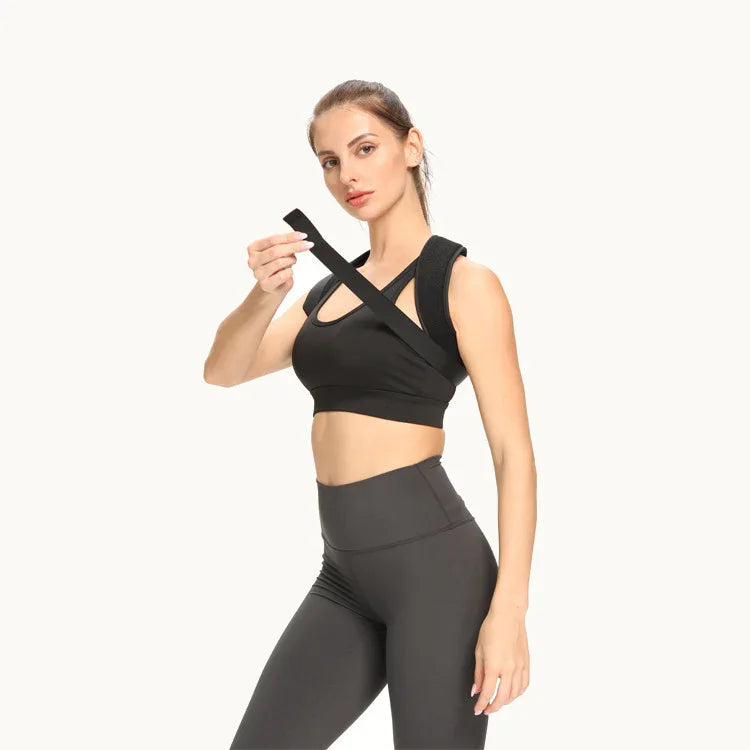 Woman wearing black posture corrector brace and athletic wear on white background