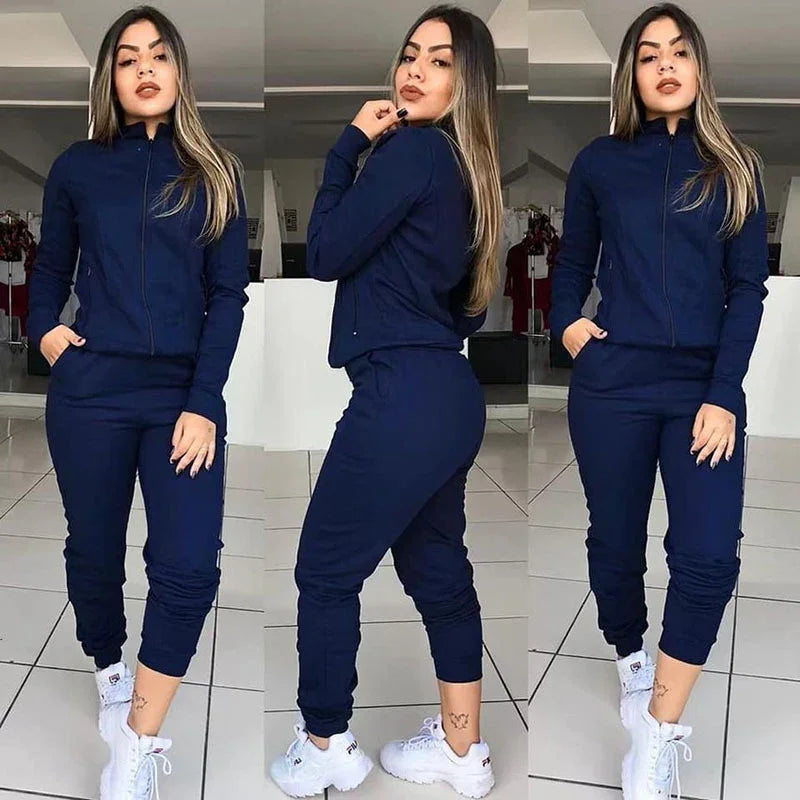 Woman modeling navy blue zip-up tracksuit and white chunky sneakers in indoor setting