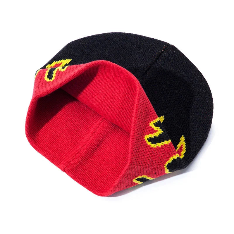Reversible knit beanie hat in black and red with yellow graphic design detail