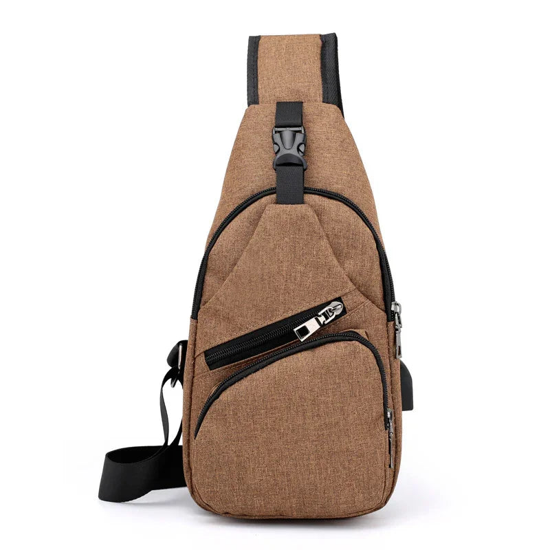 Brown canvas sling bag with black zipper pockets and adjustable shoulder strap