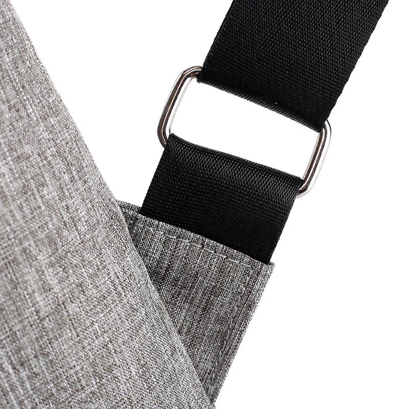 Close-up of grey fabric bag with black adjustable strap and metal buckle detail